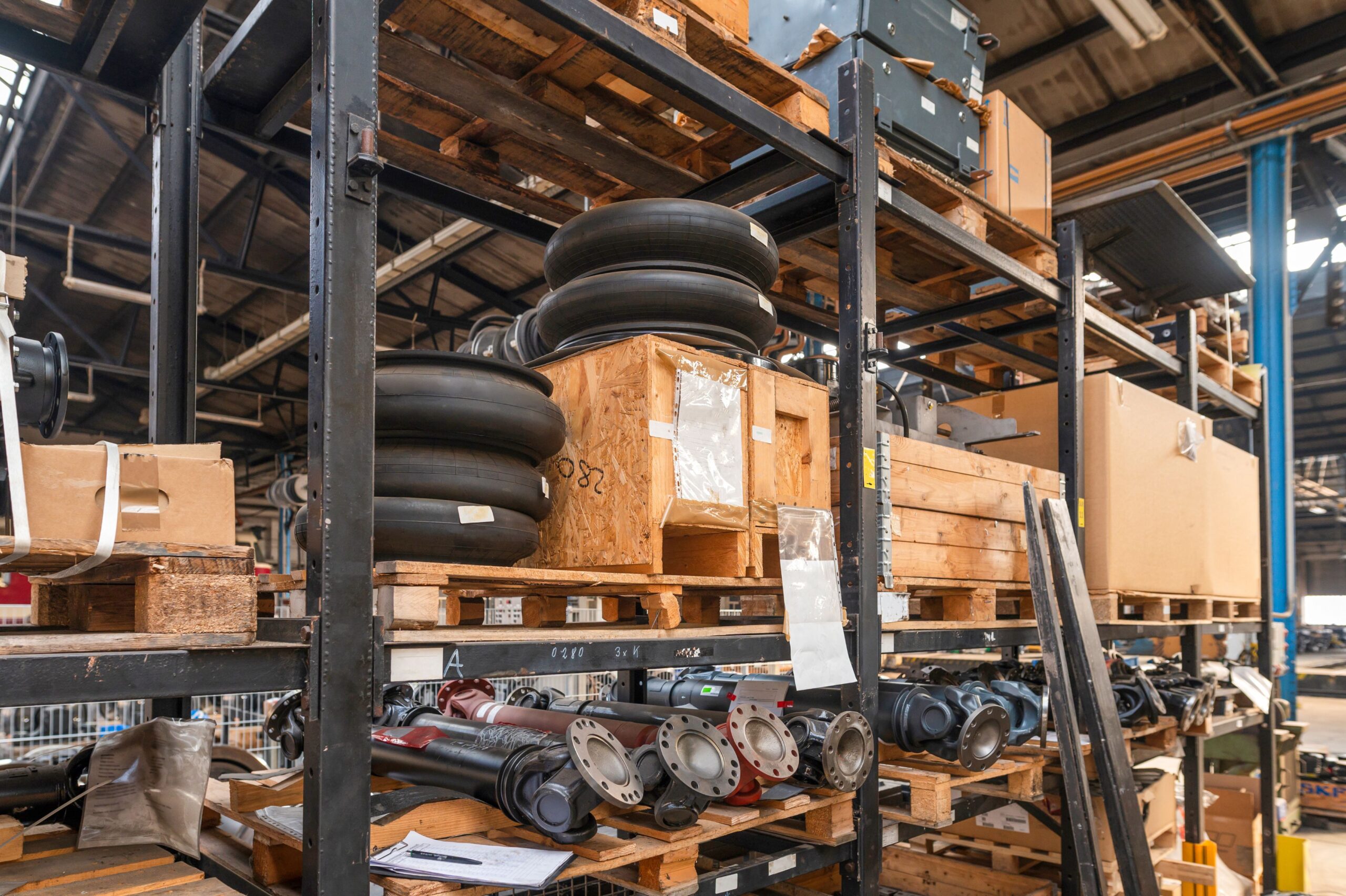 Ersatzteillager für Landmaschinen mit Oberlenker und weiteren Bauteilen in einer Werkstatt