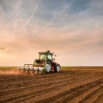 Traktor bei der Feldarbeit mit angebautem Oberlenker